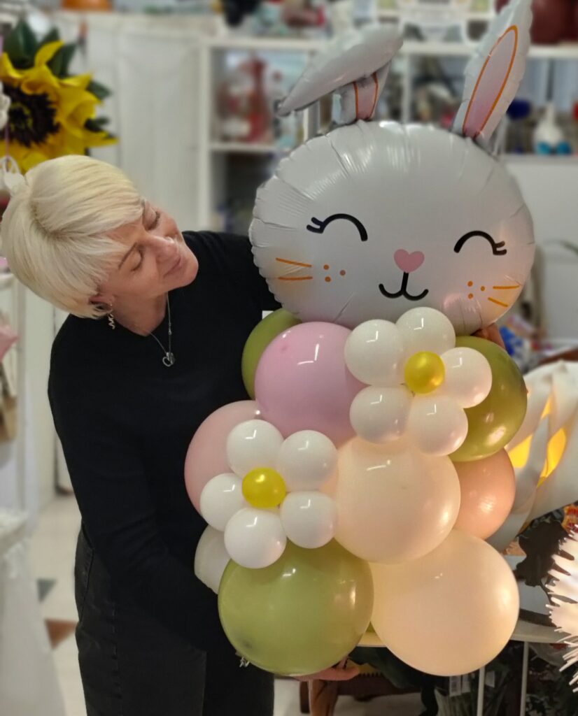 Oxana con una composizione di palloncini a forma di coniglietto nel laboratorio ArteXenia