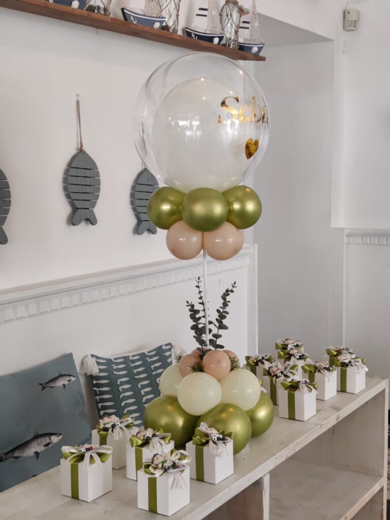 Esposizione coordinata di bomboniere bianche e verdi con palloncini